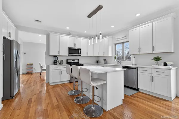 a large kitchen with a table chairs refrigerator and a stove