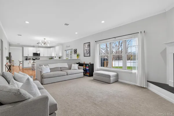 a living room with kitchen island furniture and a chandelier