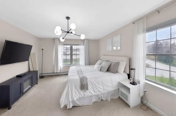 a bedroom with a balcony a bed a table and a window