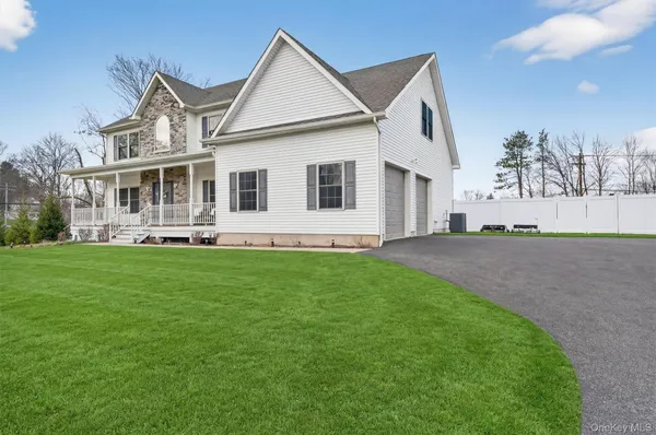 a view of a house next to a big yard and large trees