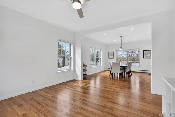 a view of a dining room with furniture a chandelier and wooden floor