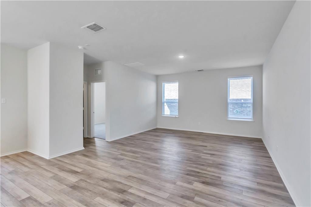 338 Pepperbark Loop Buda, TX 78610 - Photo 17 of 23 a view of an empty room with wooden floor and window