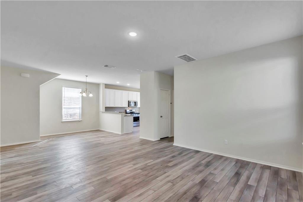 338 Pepperbark Loop Buda, TX 78610 - Photo 18 of 23 a view of empty room with wooden floor and window