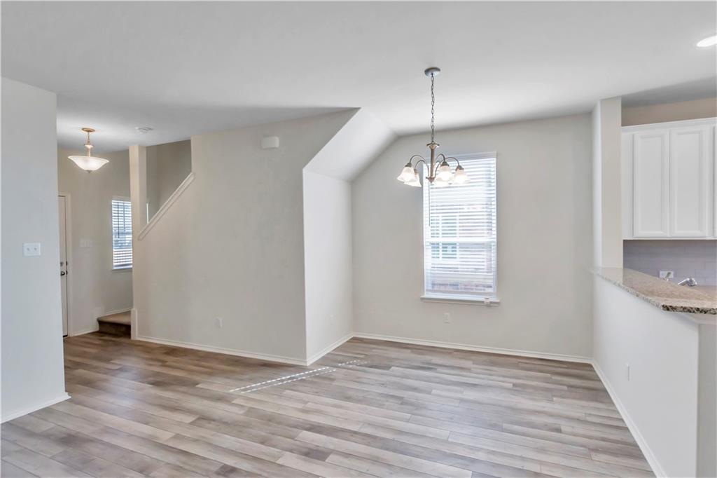 338 Pepperbark Loop Buda, TX 78610 - Photo 19 of 23 a view of an empty room with wooden floor and a window