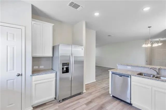 a kitchen with white cabinets and refrigerator