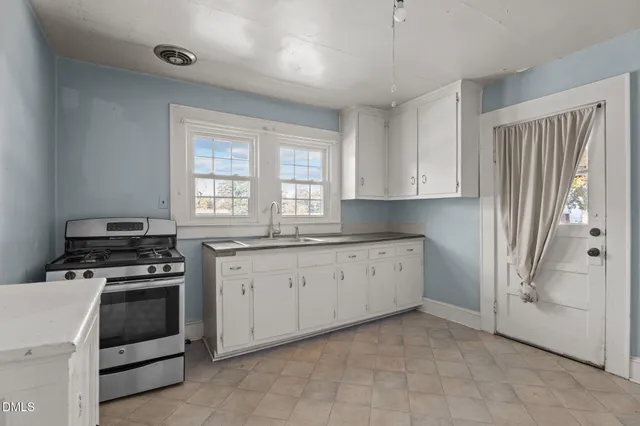 a kitchen with granite countertop a stove top oven sink and cabinets