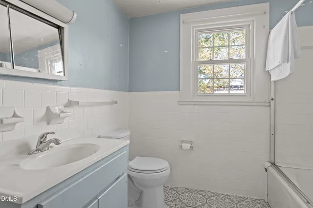 a bathroom with a sink toilet and a window