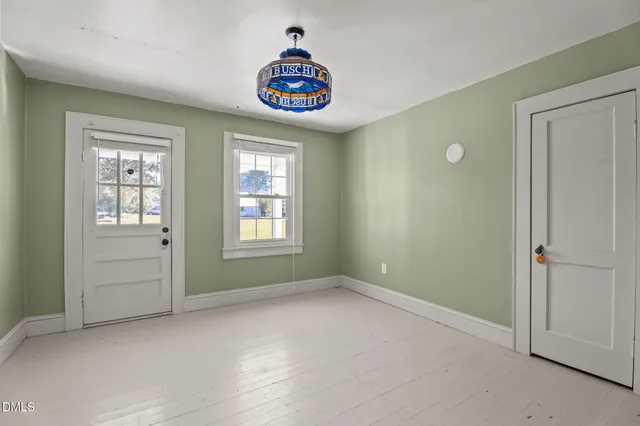 an empty room with windows and cabinet