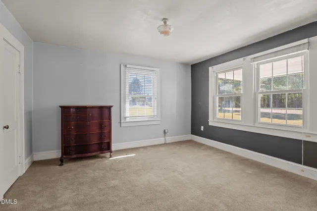 an empty room with windows and closet