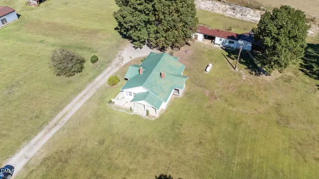 an aerial view of a house with a yard and ocean view