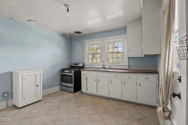 a kitchen with granite countertop a stove sink and cabinets