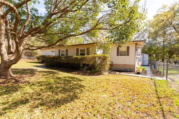 a front view of house with yard and trees around