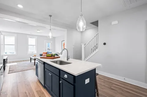 a living room with furniture a rug and a kitchen view