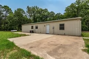 a view of a house with backyard and trees