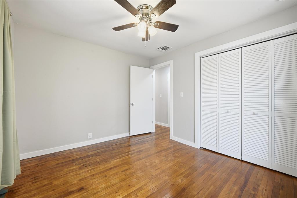 702 North Church Street Decatur, TX 76234 - Photo 12 of 36 an empty room with wooden floor ceiling fan and windows