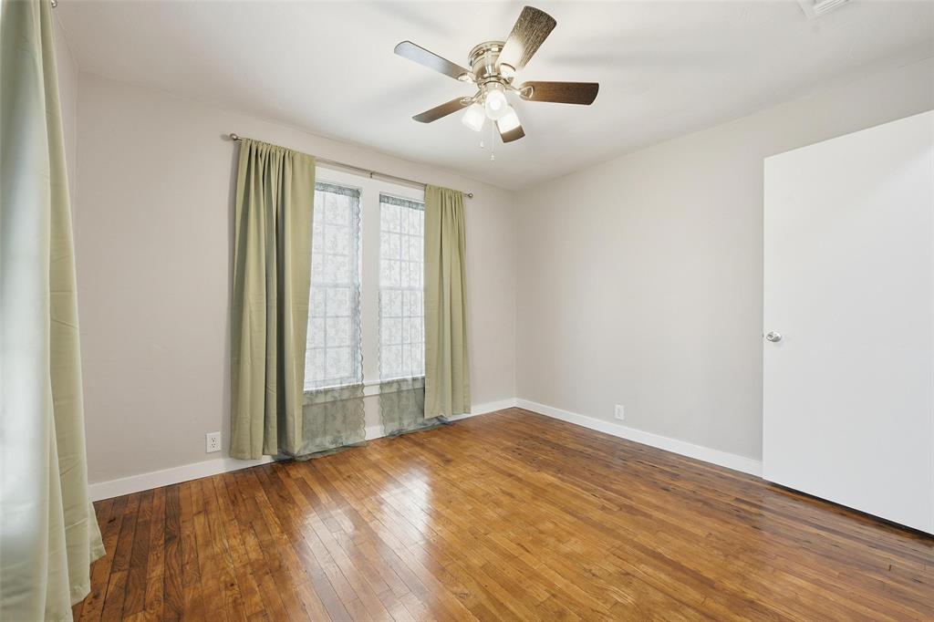 702 North Church Street Decatur, TX 76234 - Photo 13 of 36 an empty room with wooden floor and windows