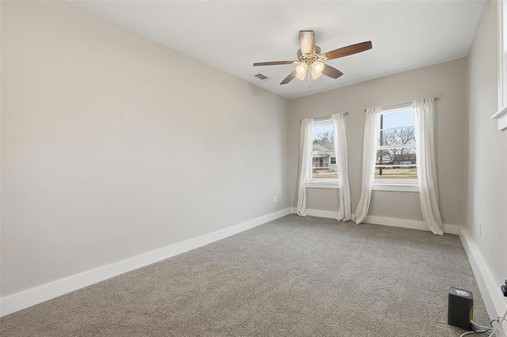 702 North Church Street Decatur, TX 76234 - Photo 15 of 36 an empty room with windows and ceiling fan