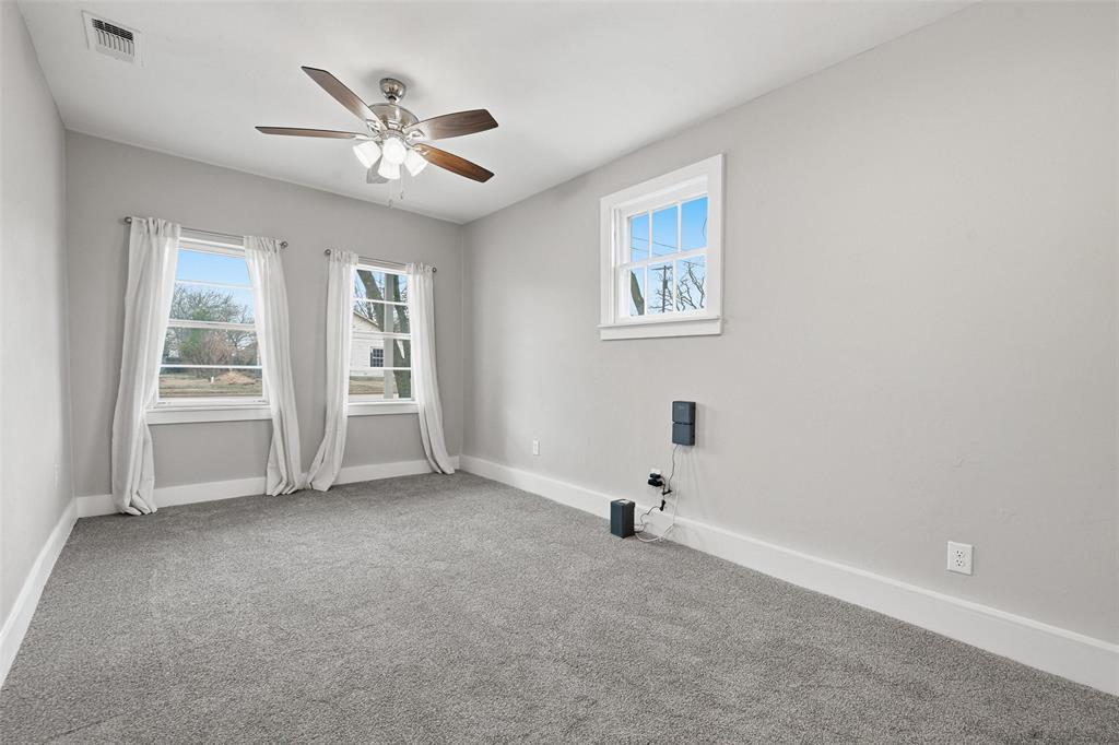 702 North Church Street Decatur, TX 76234 - Photo 16 of 36 an empty room with windows and fan