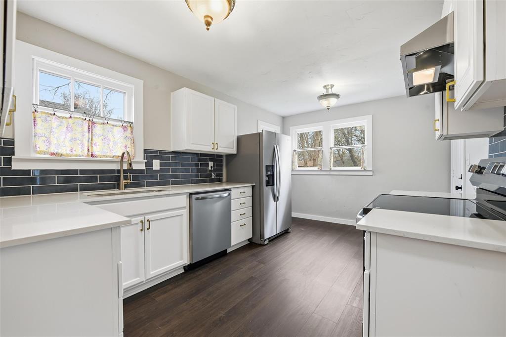 702 North Church Street Decatur, TX 76234 - Photo 24 of 36 a kitchen with granite countertop a sink cabinets and wooden floor