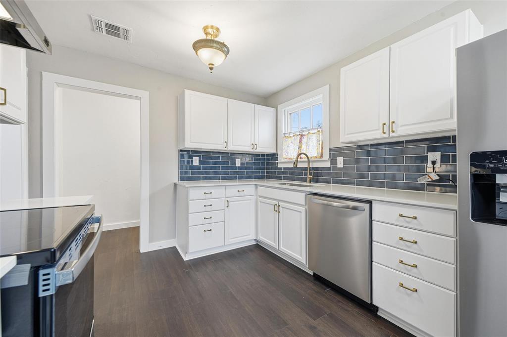 702 North Church Street Decatur, TX 76234 - Photo 25 of 36 a kitchen with granite countertop a sink cabinets and wooden floor
