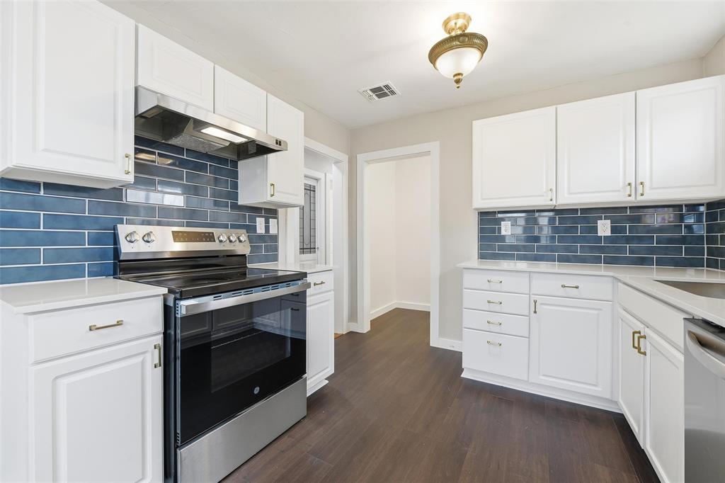 702 North Church Street Decatur, TX 76234 - Photo 26 of 36 a kitchen with cabinets stainless steel appliances and wooden floor
