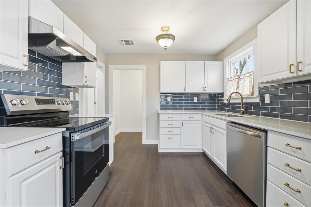 702 North Church Street Decatur, TX 76234 - Photo 28 of 36 a kitchen with granite countertop a stove top oven sink and cabinets