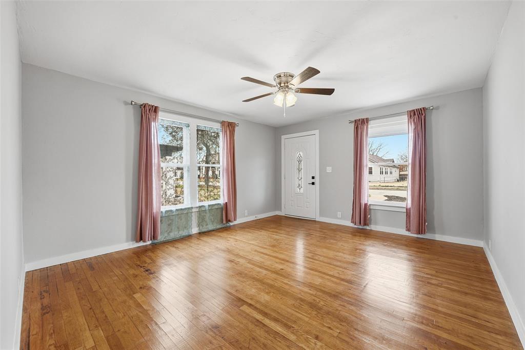 702 North Church Street Decatur, TX 76234 - Photo 5 of 36 a view of an empty room with a window and wooden floor