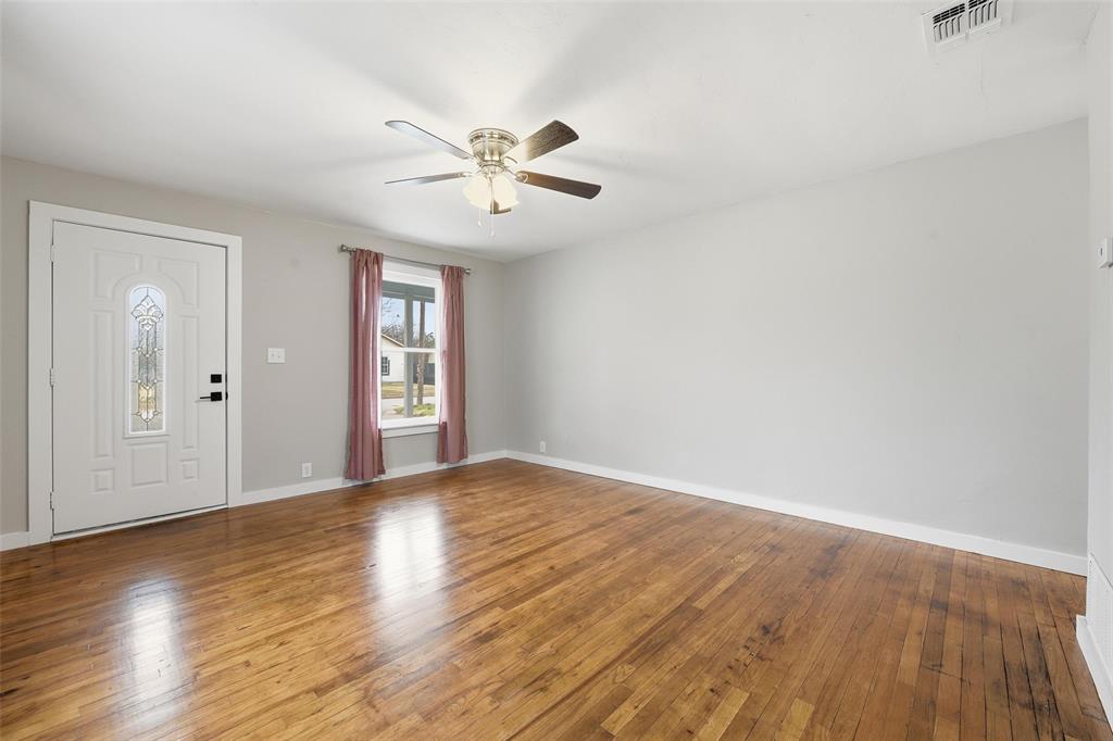 702 North Church Street Decatur, TX 76234 - Photo 8 of 36 a view of an empty room with wooden floor and window