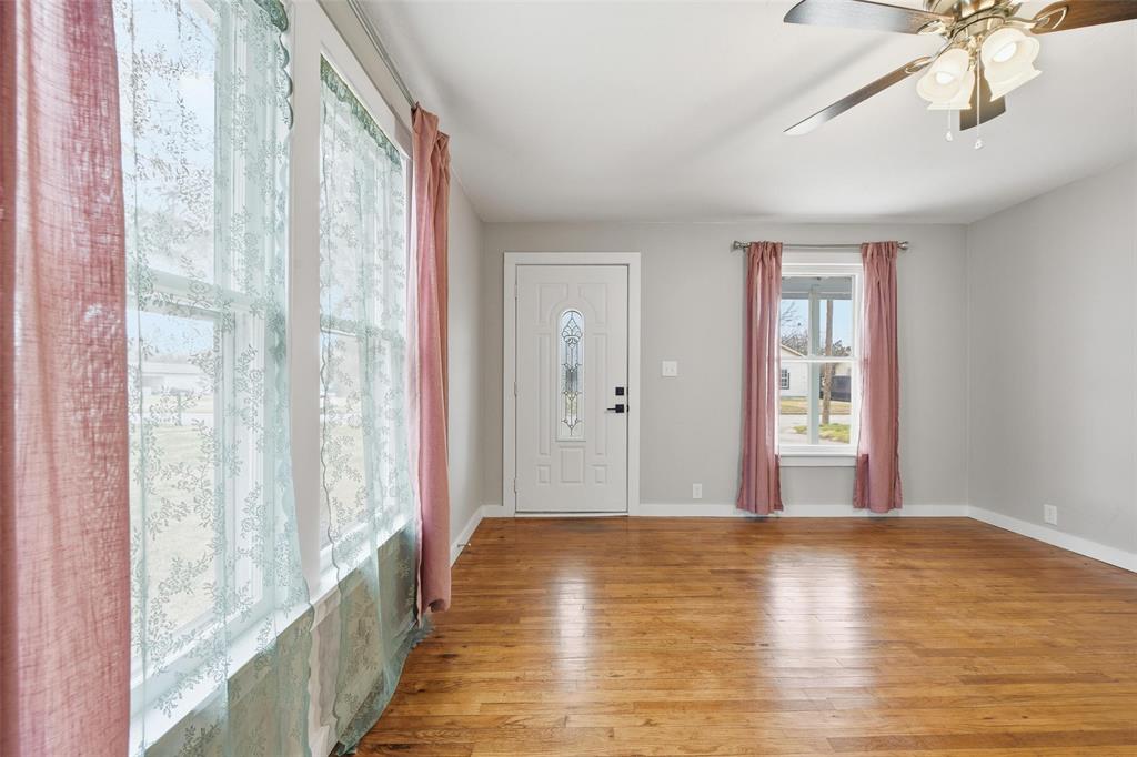 702 North Church Street Decatur, TX 76234 - Photo 9 of 36 a view of an empty room with wooden floor and a window