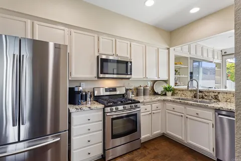 a kitchen with white cabinets and stainless steel appliances