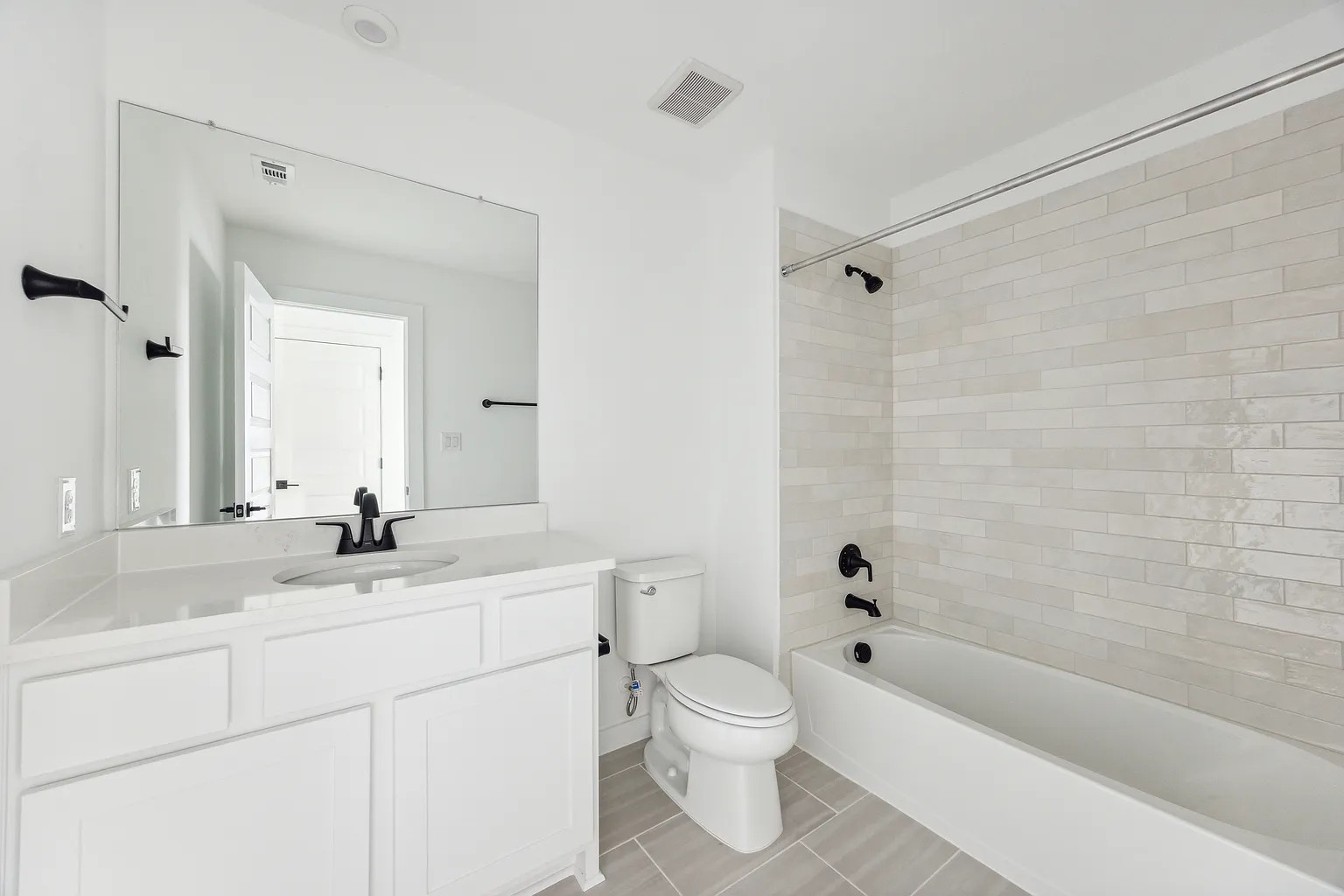 1909 Varese Path Leander, TX 78641 - Photo 32 of 40 A pristine bathroom featuring a sleek vanity, contemporary fixtures, and a shower with subway tile.
