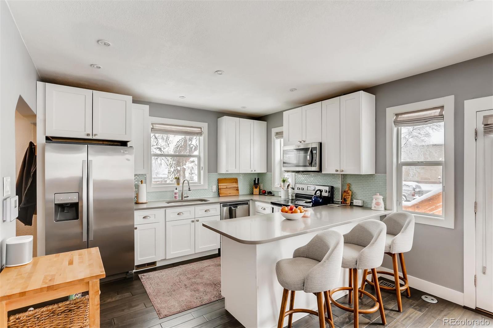 3510 Elizabeth Street Denver, CO 80205 - Photo 12 of 39 a kitchen with stainless steel appliances granite countertop a sink a stove a refrigerator cabinets and a dining table with wooden floor