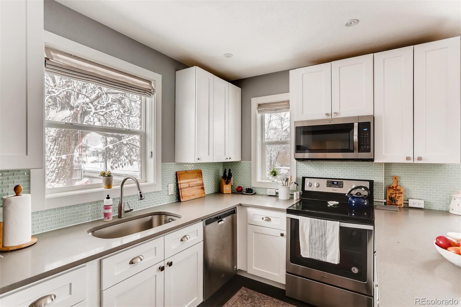 3510 Elizabeth Street Denver, CO 80205 - Photo 15 of 39 a kitchen with stainless steel appliances white cabinets a sink and a stove