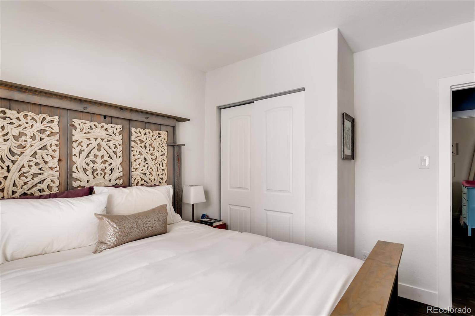3510 Elizabeth Street Denver, CO 80205 - Photo 18 of 39 a bedroom with a large bed and a wooden floor