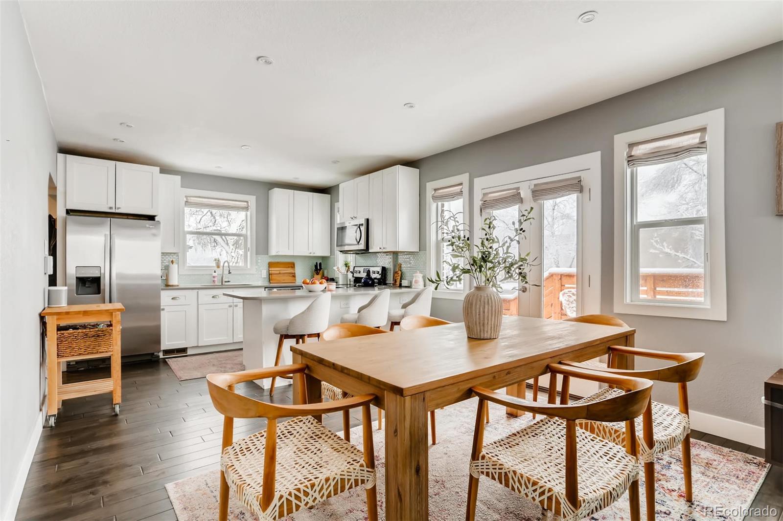 3510 Elizabeth Street Denver, CO 80205 - Photo 10 of 39 a open dining room with stainless steel appliances kitchen island granite countertop a table chairs and a refrigerator