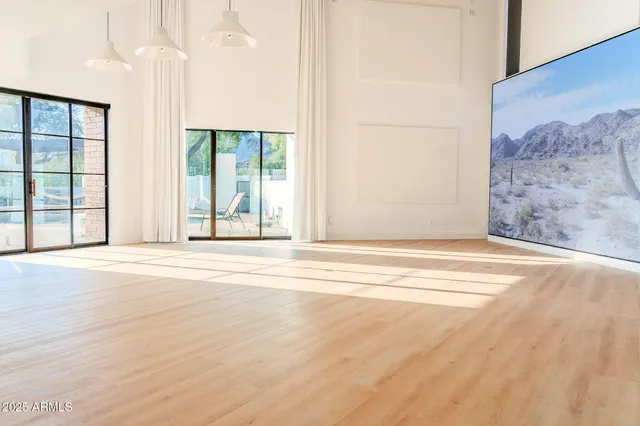a view of a livingroom with wooden floor and a large window