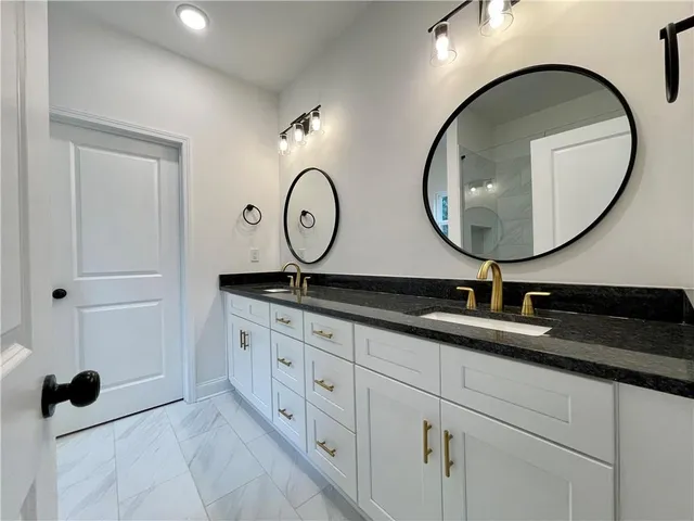 a bathroom with a granite countertop sink and a mirror