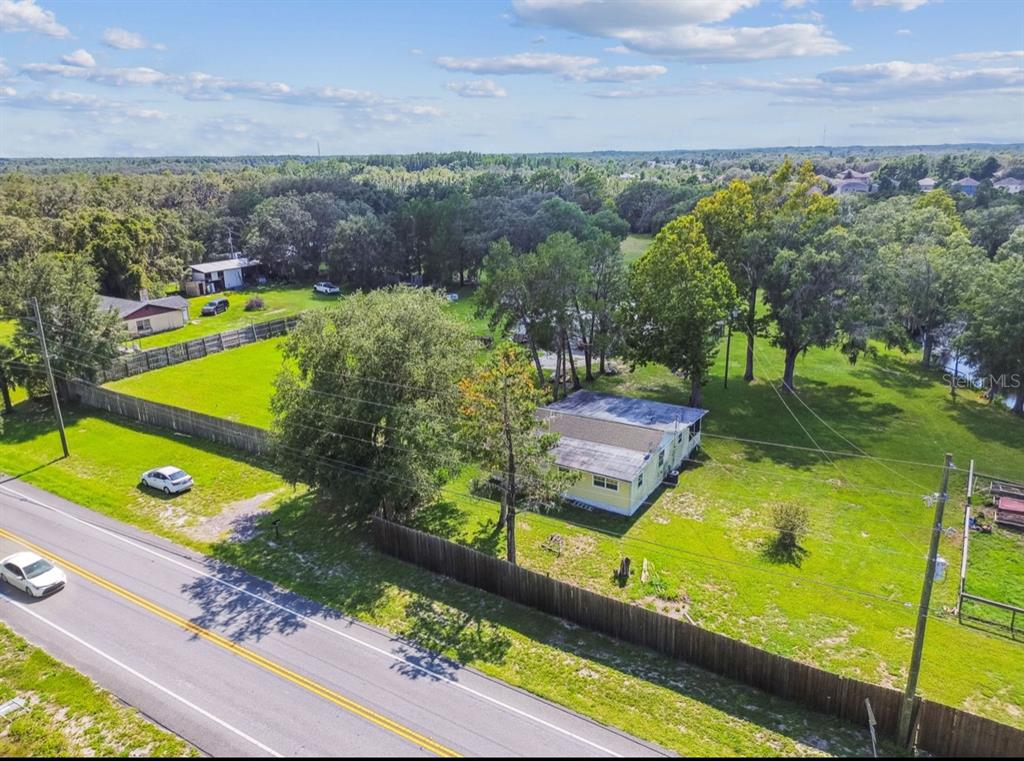 12321 Shady Hills Road Spring Hill, FL 34610 - Photo 9 of 30 a view of a swimming pool with lawn chairs under an umbrella