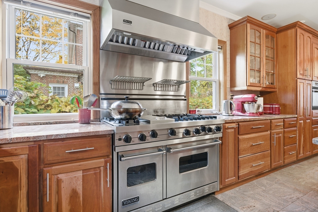 6 Elba Street Brookline, MA 02446 - Photo 11 of 34 a kitchen with stainless steel appliances wooden cabinets and a stove top oven