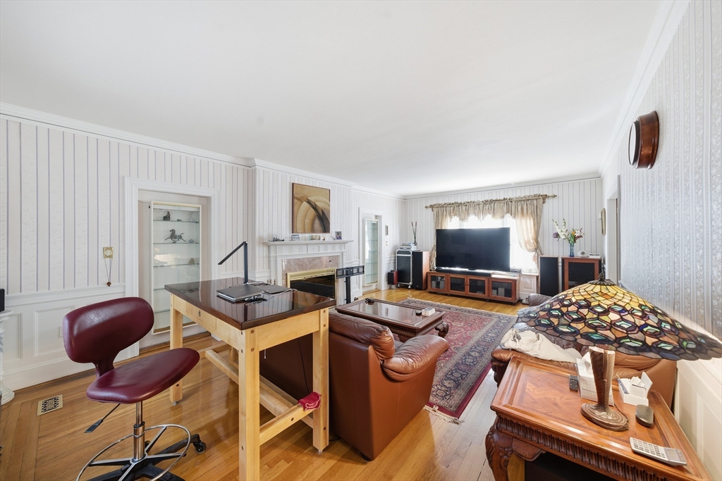 6 Elba Street Brookline, MA 02446 - Photo 15 of 34 a living room with furniture a flat screen tv and kitchen view