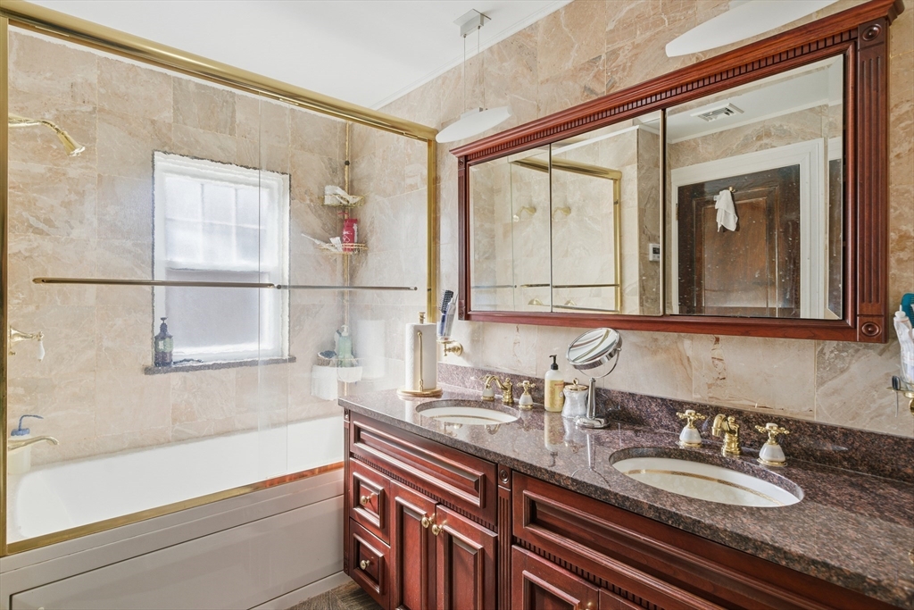 6 Elba Street Brookline, MA 02446 - Photo 20 of 34 a bathroom with a granite countertop sink and a large mirror