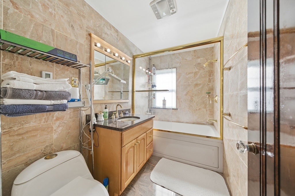 6 Elba Street Brookline, MA 02446 - Photo 23 of 34 a bathroom with a granite countertop sink a toilet and shower