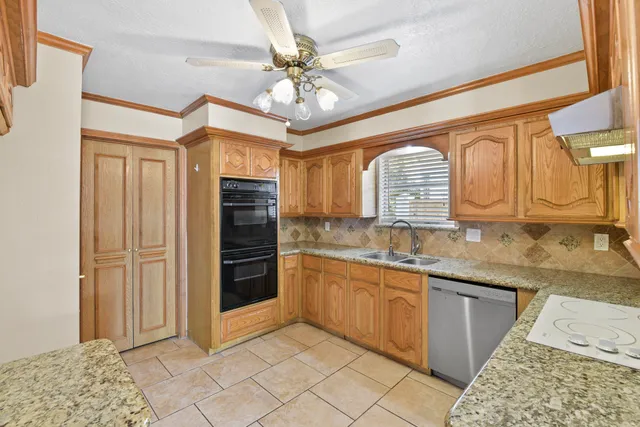 a bathroom with a granite countertop sink a mirror and cabinets