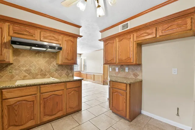 a kitchen with stainless steel appliances granite countertop a refrigerator and a stove
