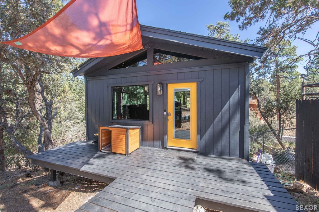 186 Riverside Avenue Sugarloaf, CA 92386 - Photo 28 of 34 a front view of a house with a wooden floor and a bench