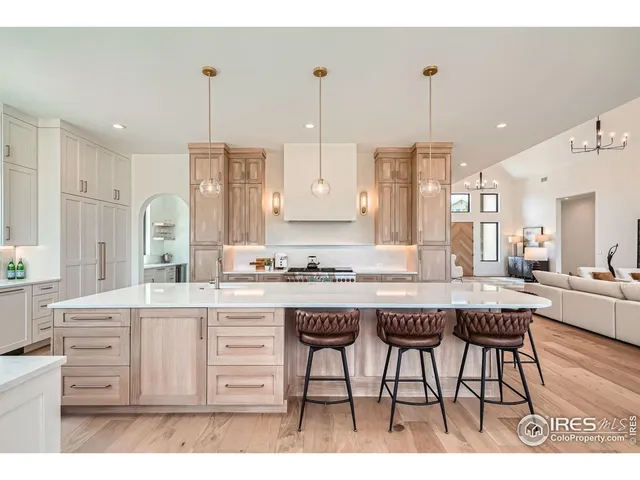 a kitchen with kitchen island granite countertop a table chairs sink and cabinets