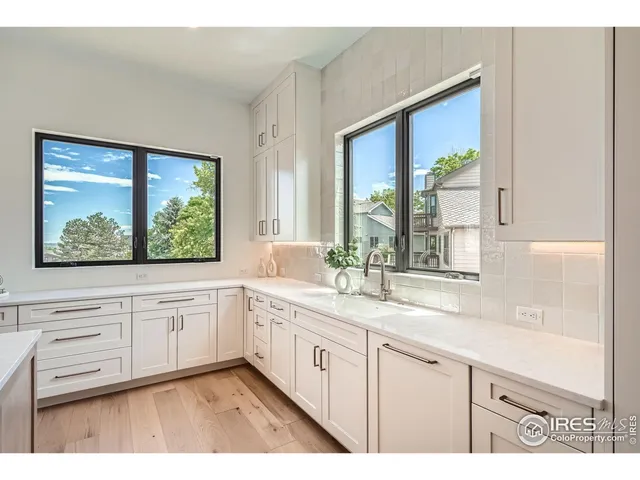 a view of a kitchen with sink and dishwasher with wooden floor