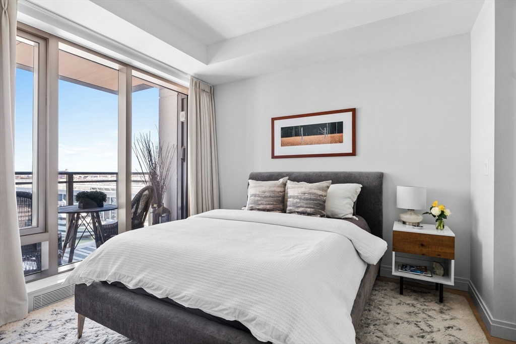 133 Seaport Boulevard, Unit 920 Boston, MA 02210 - Photo 14 of 28 a large bed sitting in a bedroom and a table