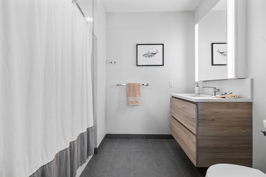 133 Seaport Boulevard, Unit 920 Boston, MA 02210 - Photo 16 of 28 a bathroom with a sink and a mirror