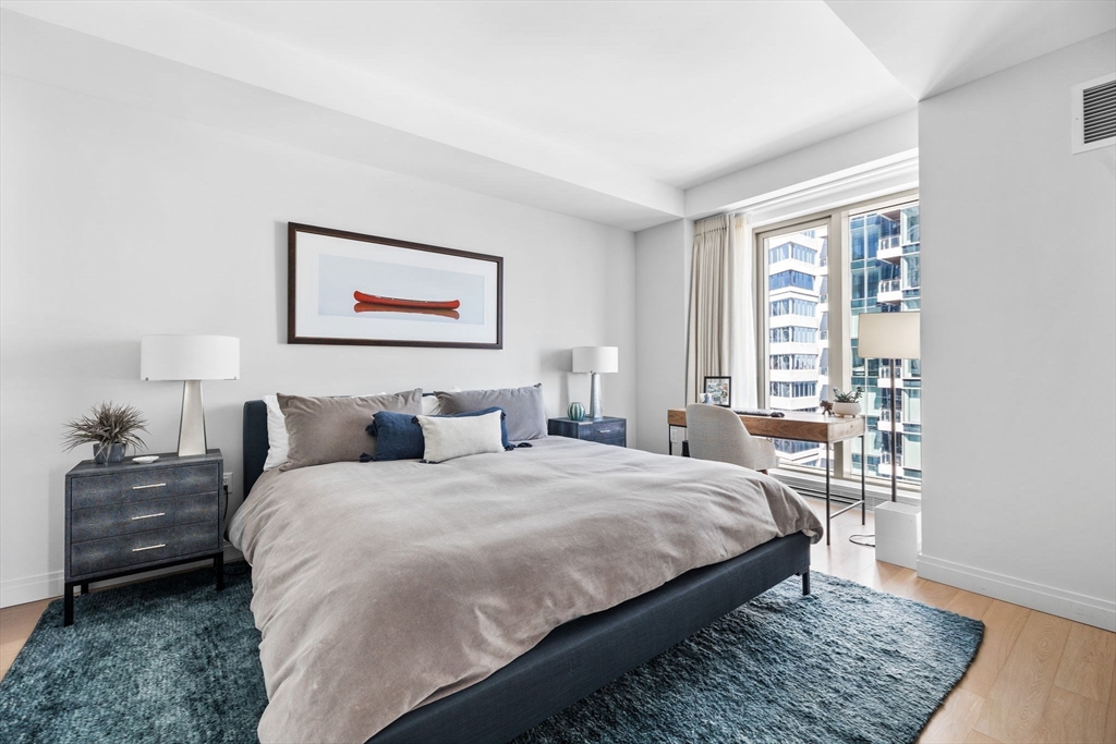 133 Seaport Boulevard, Unit 920 Boston, MA 02210 - Photo 5 of 28 a bedroom with a bed wooden floor and a large window